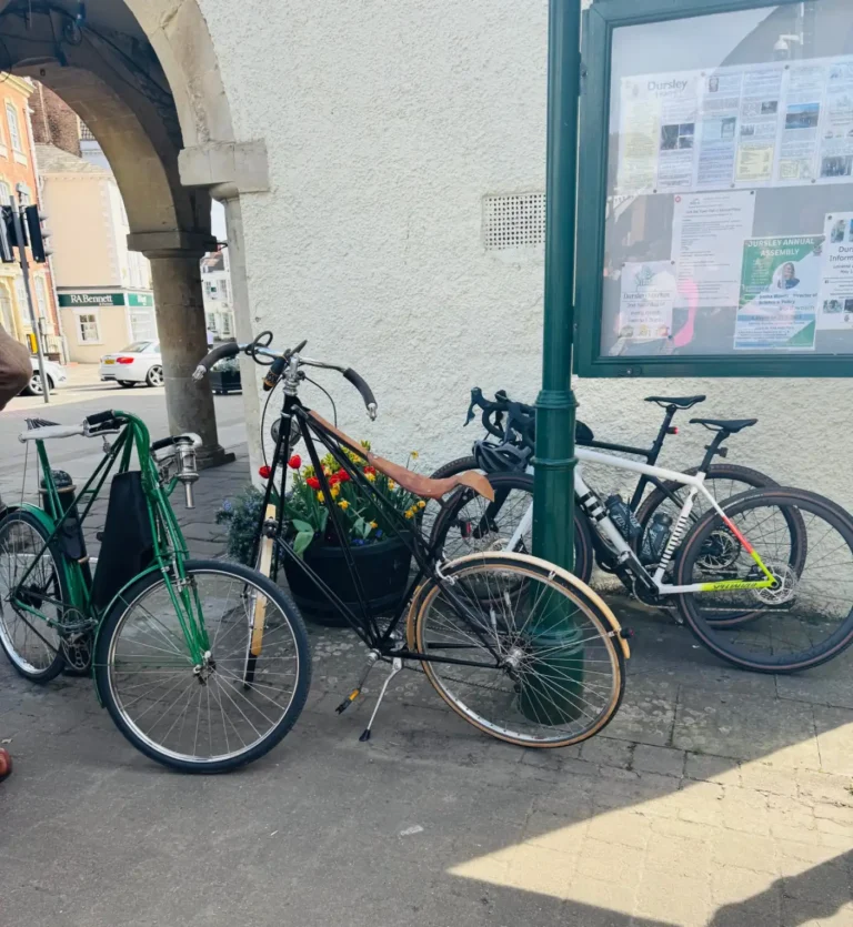 Two Pedersen bicycles parked alongside two modern bicycles in the street outside the Town Hall.